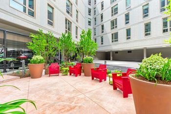 A courtyard with red chairs and plants